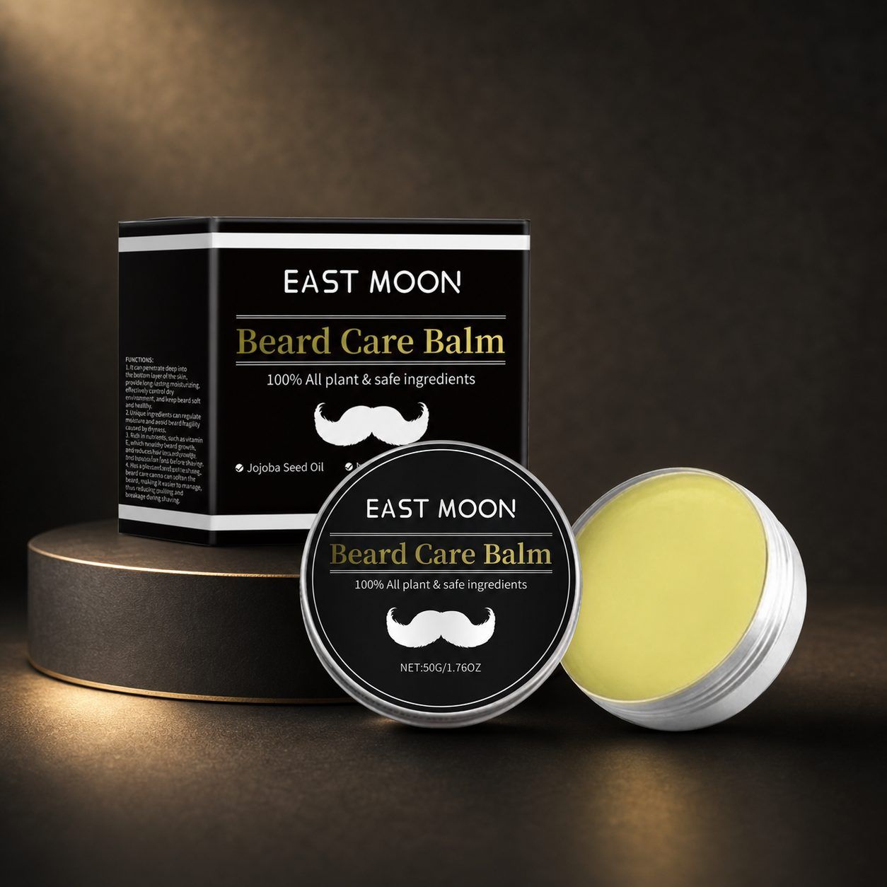 EAST MOON Beard Care Balm shown with its black and white product box, a round lid, and an open silver tin revealing pale yellow balm, arranged on a dark studio background with warm spotlighting.