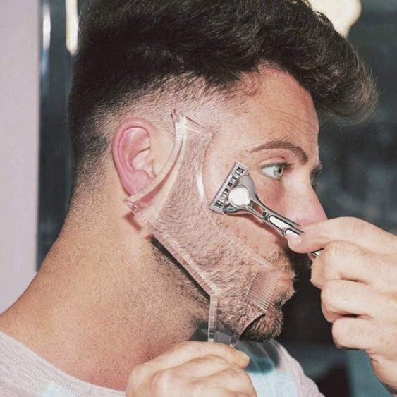 Man shaving his beard with a razor held up to the camera.