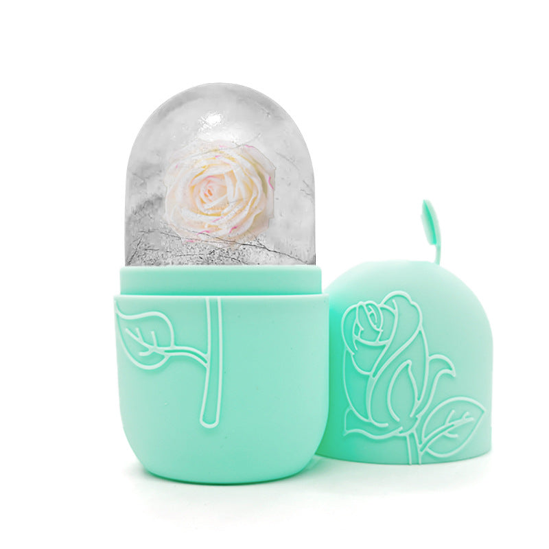 Mint green container with a rose design, containing a white rose inside a glass dome on a white background