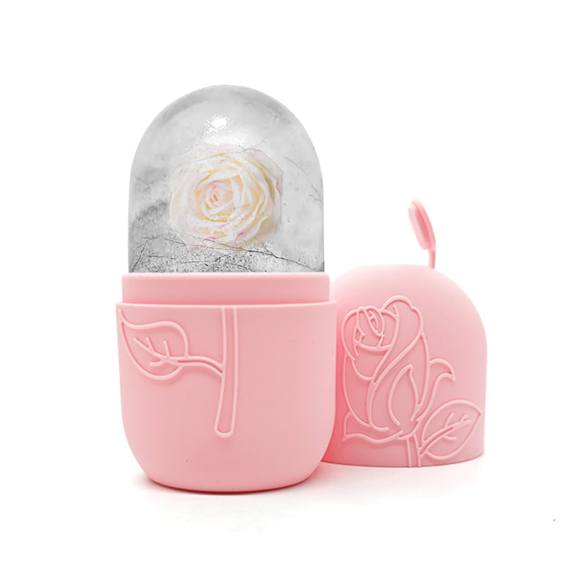 Pink container with a rose design holding a snow globe with a white rose inside on a white background