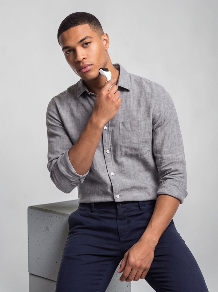 A man using a TheGromify titanium beard growth derma roller on his cheek to stimulate hair follicles.