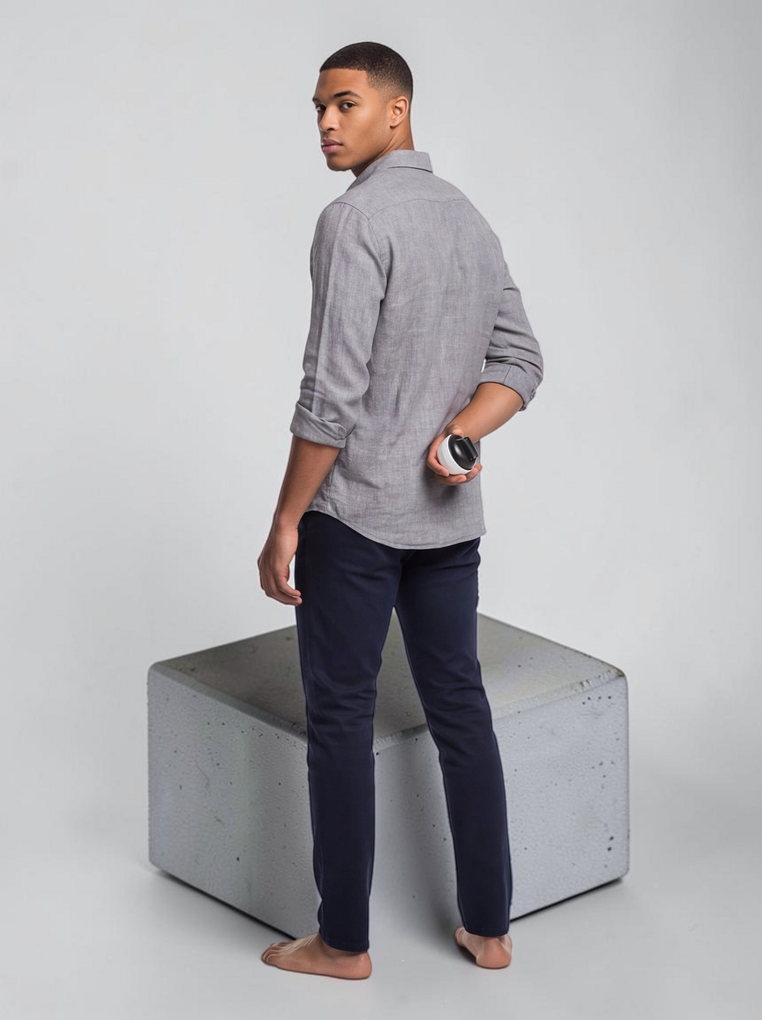 TheGromify titanium beard growth derma roller held by a man in a grey shirt against a white studio background