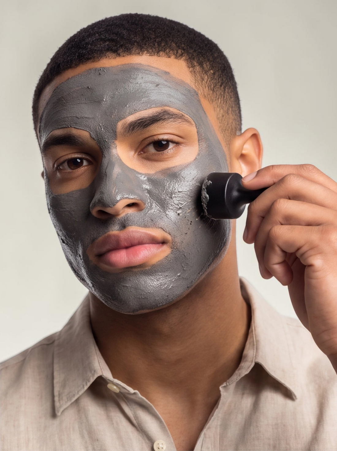 TheGromify magnetic pore-detox clay mask applied to a man's face, being removed with a handheld magnetic tool.