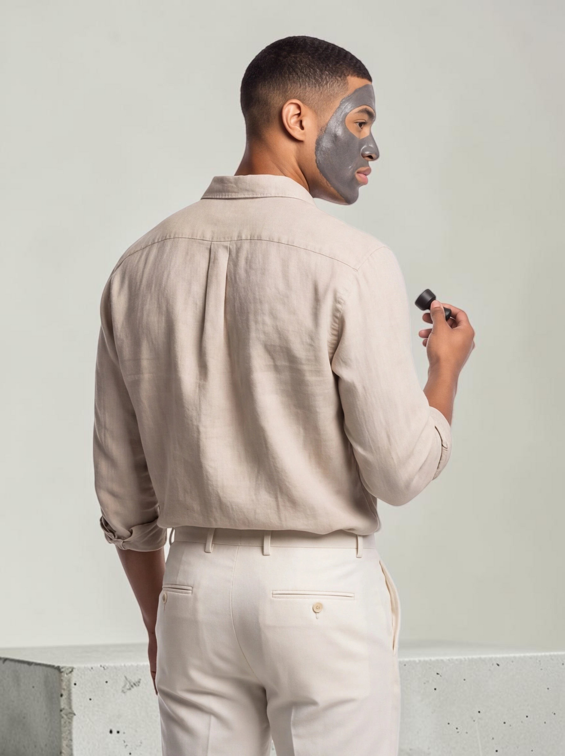 TheGromify man wearing a grey magnetic clay mask on his face while holding a magnetic removal tool