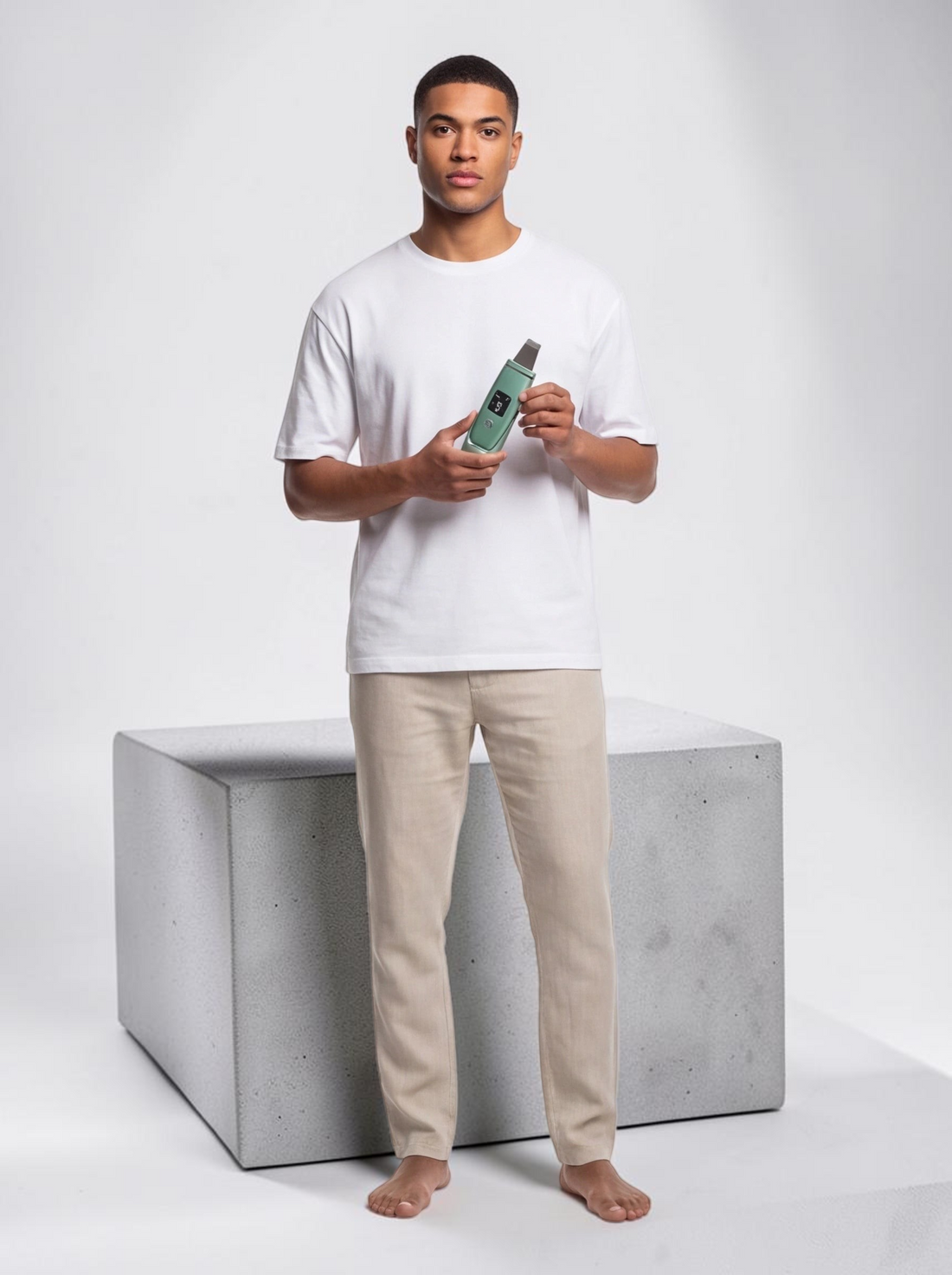 A man holding a sage green TheGromify ultrasonic skin spatula with an LED display for facial cleansing and exfoliation.
