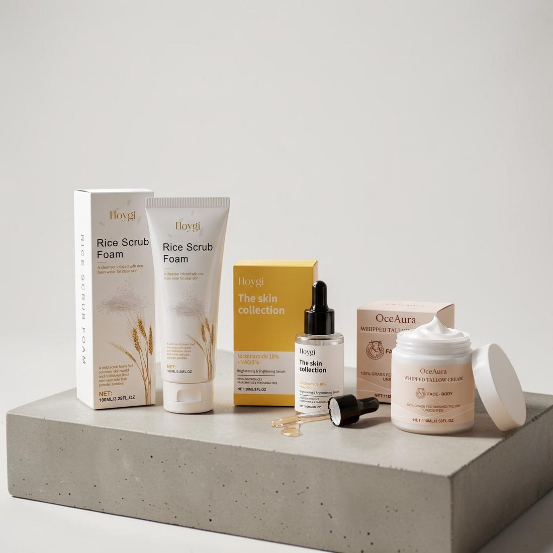 TheGromify 3-step skincare kit featuring rice scrub foam, brightening serum, and whipped tallow cream on a stone base.