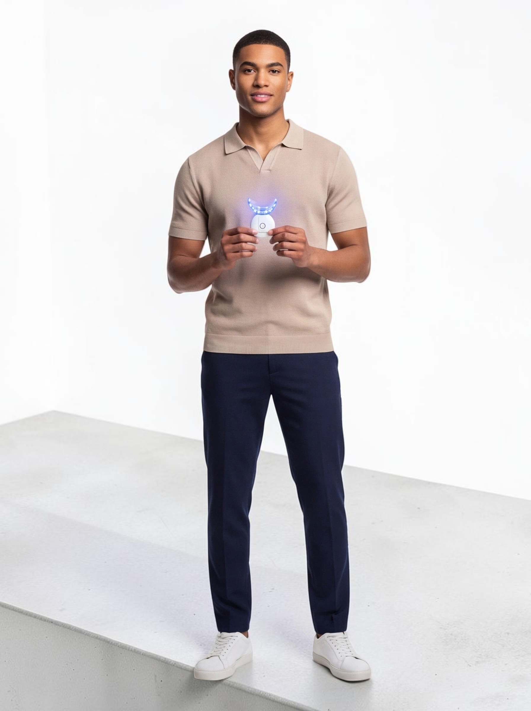 A man holding a TheGromify 32-LED teeth whitening tray that glows with blue light for at-home dental care.