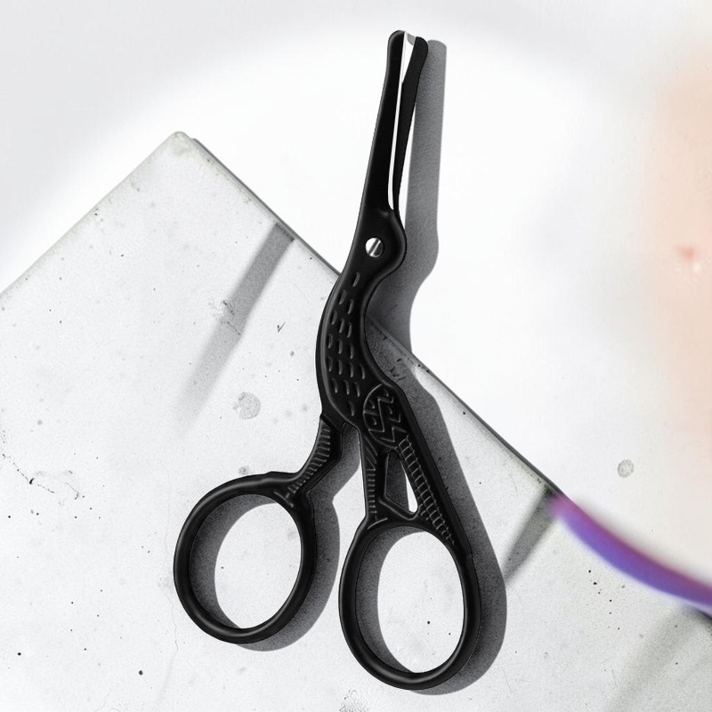 TheGromify matte black stork-shaped grooming scissors for precise nose and ear hair trimming on a stone surface.
