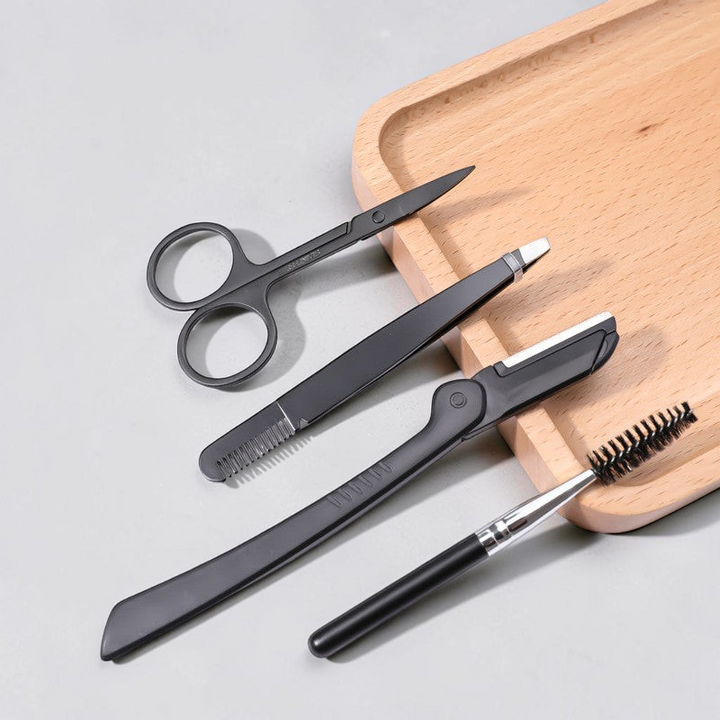 TheGromify precision eyebrow grooming kit featuring black stainless steel scissors, tweezers, razor, and spoolie brush.
