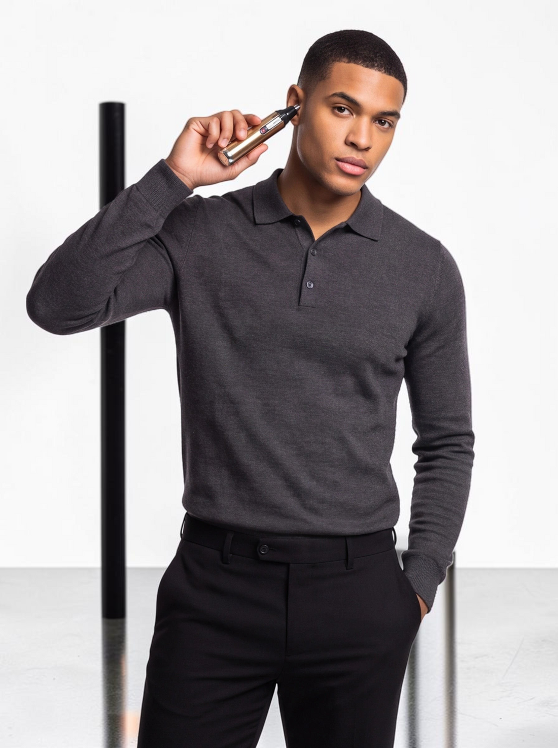 TheGromify electric nose and ear hair trimmer in gold being used by a man in a grey polo shirt
