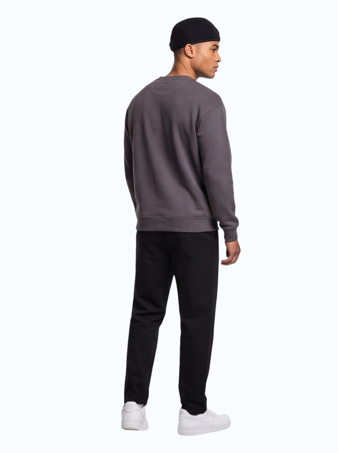 TheGromify model wearing a dark grey sweatshirt and black trousers, viewed from the back against a white background.