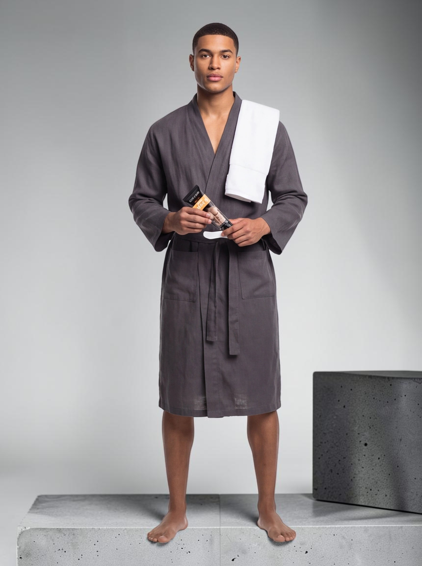 TheGromify men's body hair removal cream held by a man in a grey robe, promoting smooth skin without razor irritation.