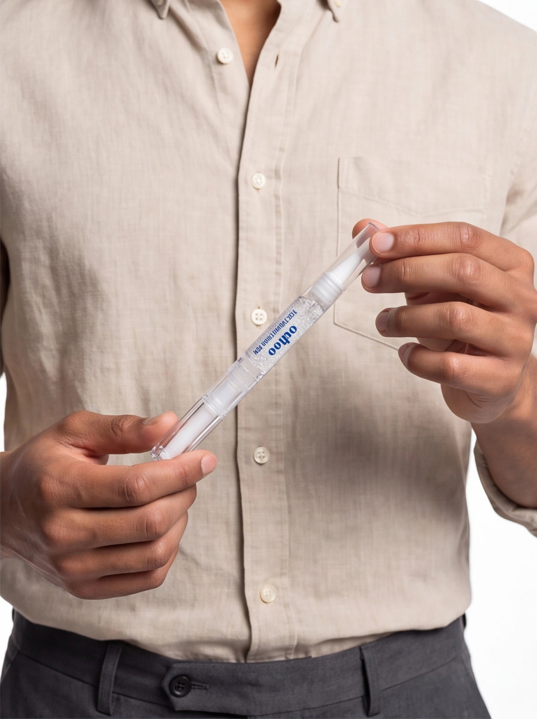 TheGromify natural teeth whitening pen held by a person wearing a beige linen shirt for quick daily enamel brightening.
