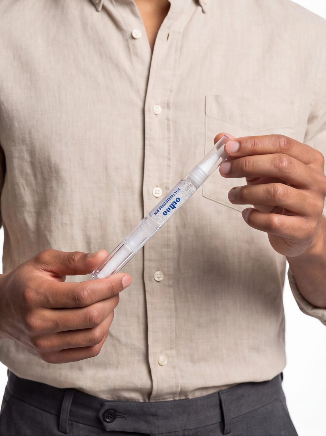 TheGromify natural teeth whitening pen held by a person wearing a beige linen shirt for quick daily enamel brightening.