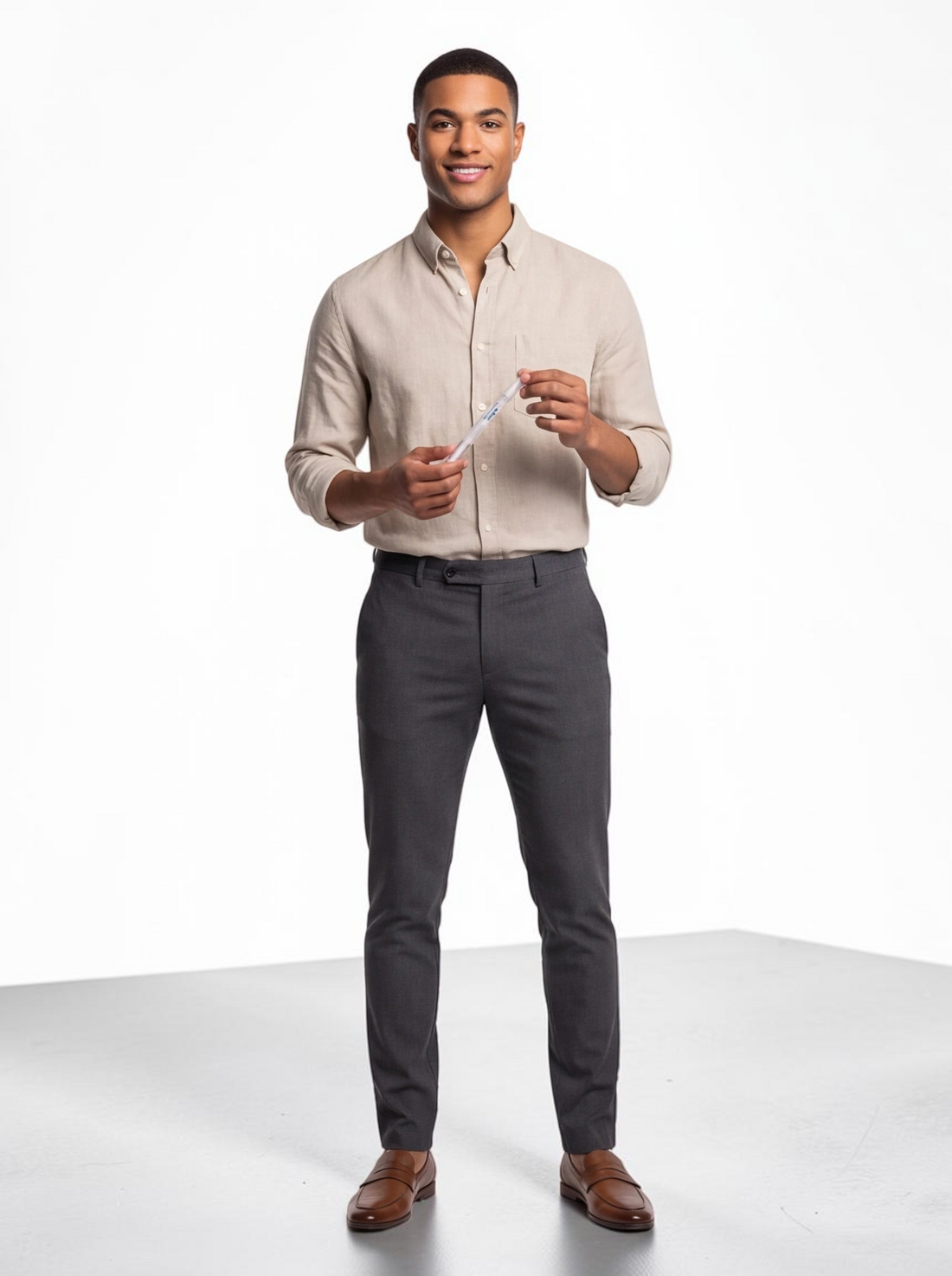 A smiling man in a beige linen shirt holding a TheGromify natural teeth whitening pen against a white background.