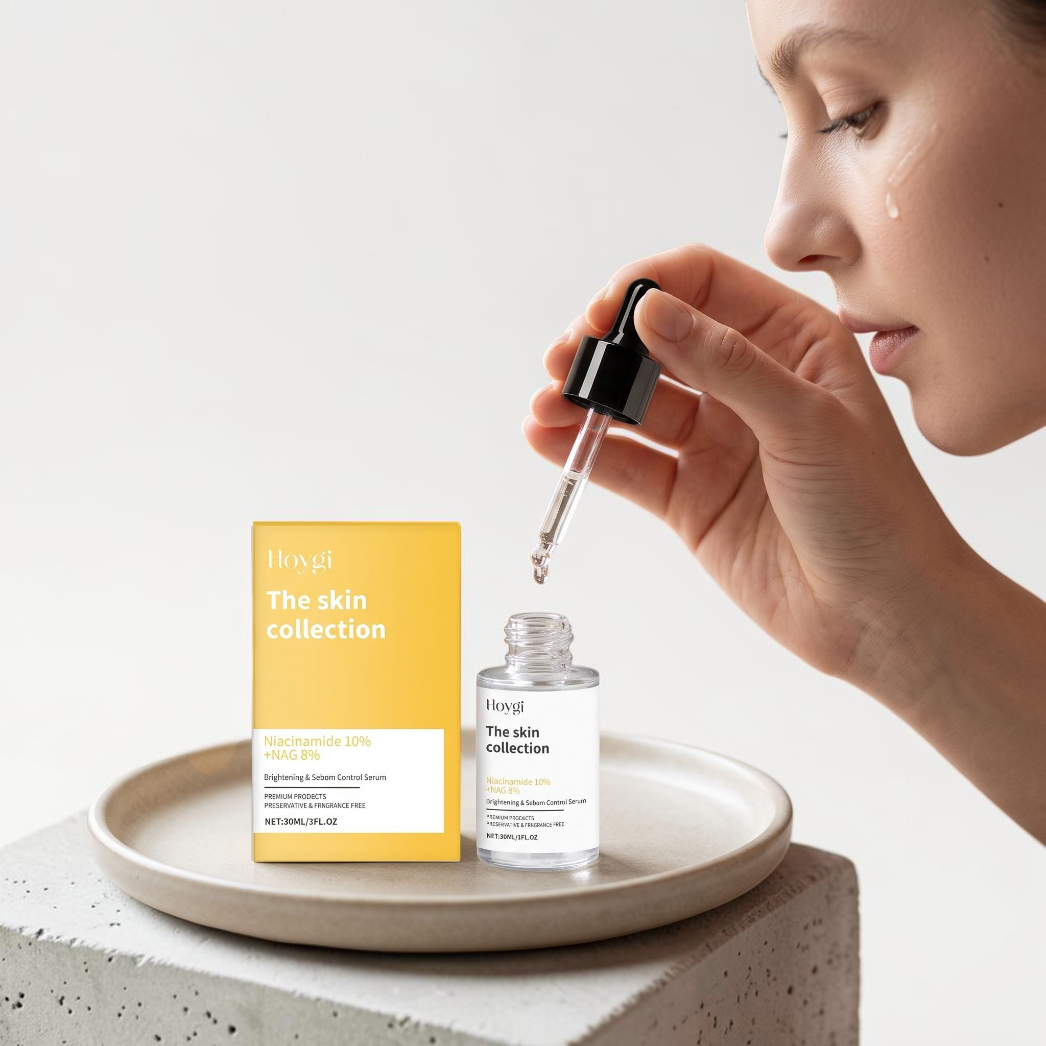 TheGromify Nicotinamide Brightening Face Serum bottle and yellow box on a stone tray with a woman applying the serum.