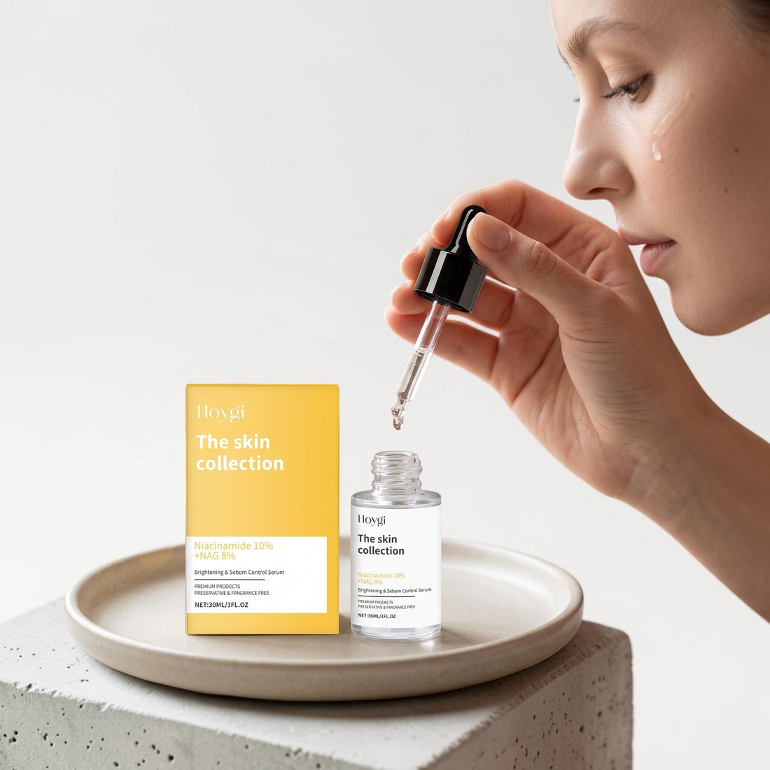 TheGromify Nicotinamide Brightening Face Serum bottle and yellow box on a stone tray with a woman applying the serum.