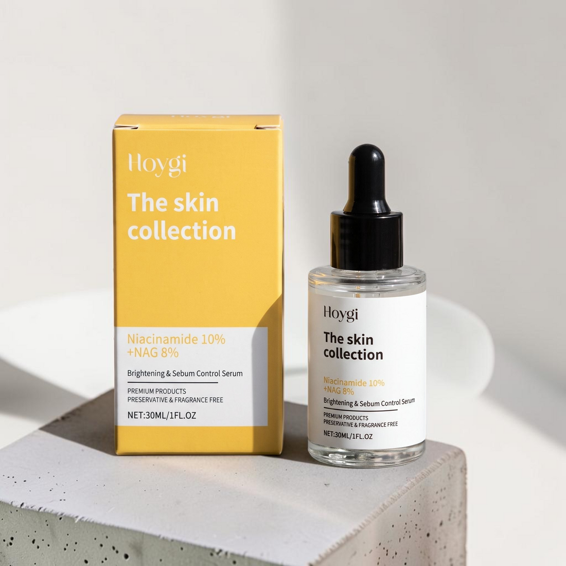 TheGromify Nicotinamide Brightening Face Serum bottle and yellow box on a concrete block for oily skin care.