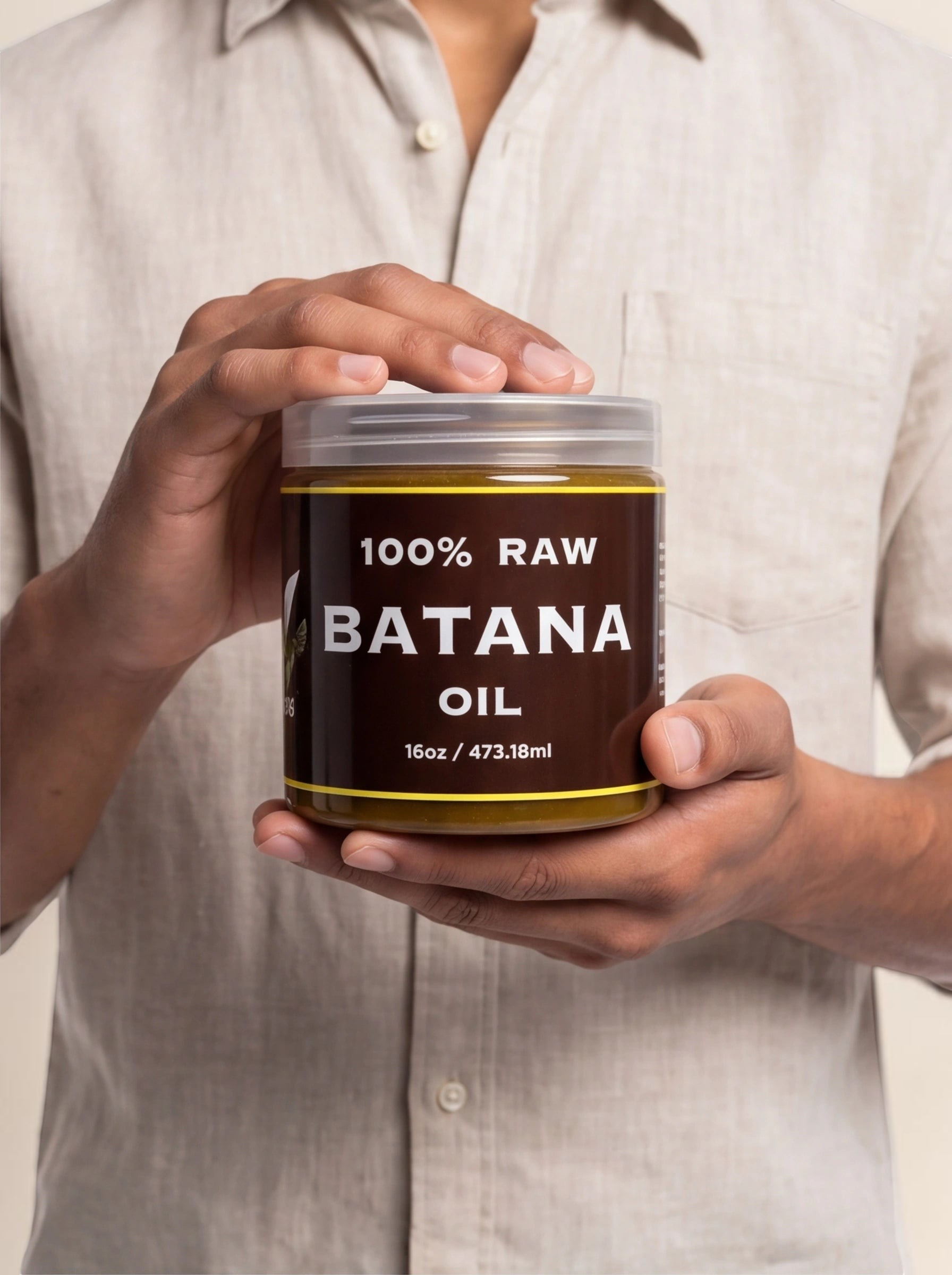 TheGromify 100% raw batana oil hair mask in a 16oz clear jar held by a person wearing a beige linen shirt