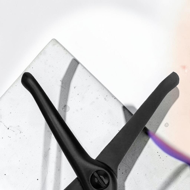 TheGromify rechargeable nose and ear hair trimmer in matte black with a sleek, ergonomic design on a stone surface.