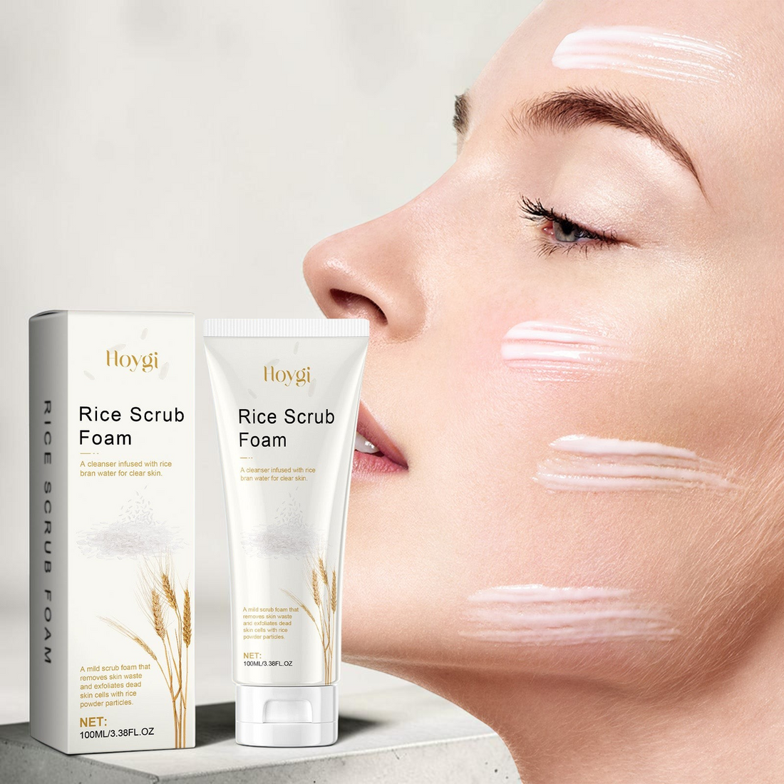 TheGromify Rice Scrub Foam cleanser in a white tube and box next to a woman with cream applied to her face