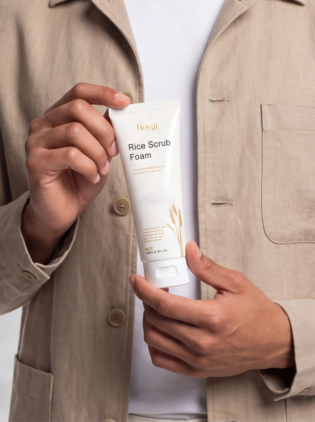 TheGromify Rice Water Daily Face Cleanser in a white squeeze tube held by a man wearing a beige linen shirt.