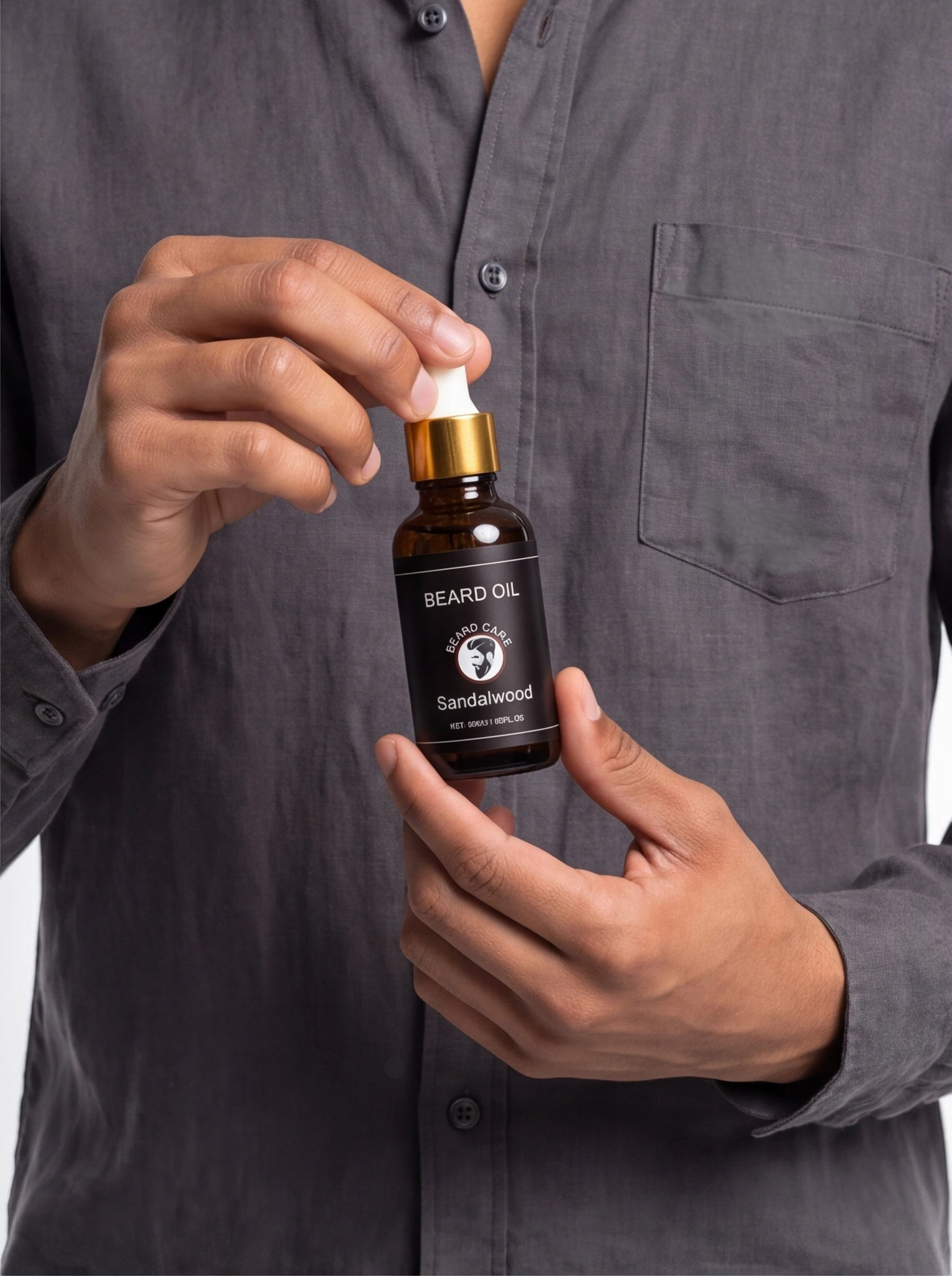 TheGromify Sandalwood and Vitamin E beard oil in an amber glass dropper bottle held by a man in a grey shirt.