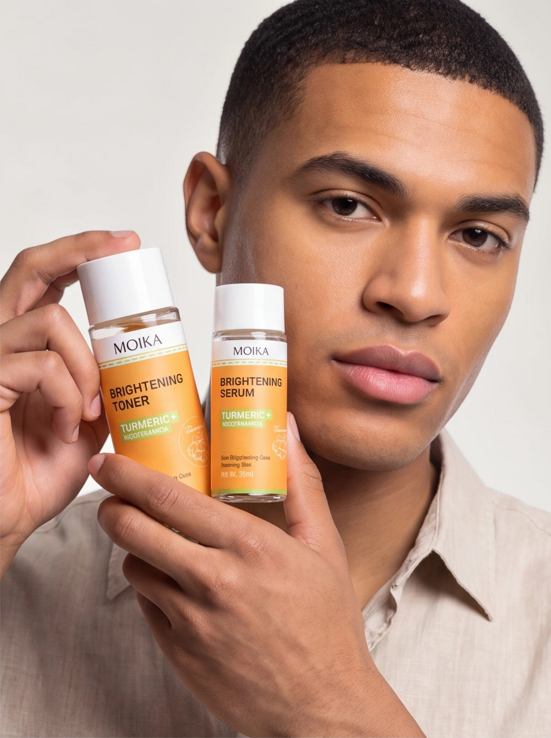 A man holding TheGromify Turmeric and Nicotinamide brightening toner and serum bottles for a skincare routine.