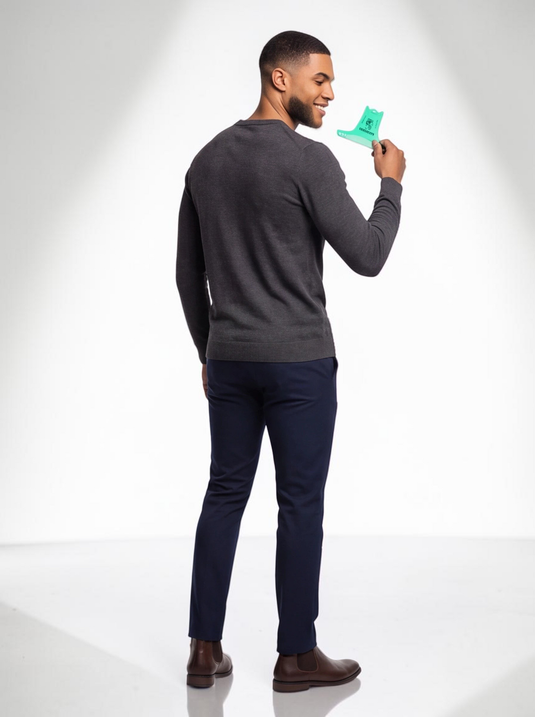 TheGromify man holding a green pocket-sized wide-tooth beard and hair comb while looking over his shoulder